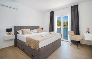a bedroom with a large bed and a chair at Nice Home In Rogotin With Harbor View in Rogotin