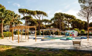 a playground with a slide and a swing set at Hotel New Barcavela in Santa Margherita di Pula