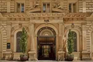 a building with an entrance with two plants in front at Sir Prague, part of Sircle Collection in Prague