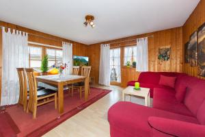 sala de estar con sofá rojo y mesa en Ferienhaus Beim Veitele, en Mittenwald