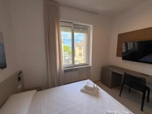 a bedroom with a bed and a desk and a window at MONTELLA B&b in Gaeta
