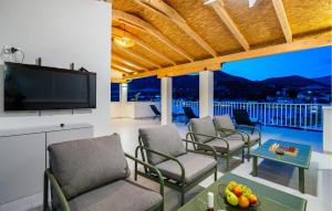 a living room with chairs and a flat screen tv at Nice Home In Rogotin With Harbor View in Rogotin