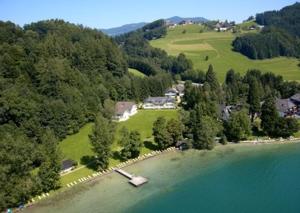 an aerial view of a house on the shore of a lake at Hotel Seehof in Loibichl