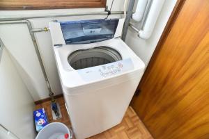 a washing machine in a small room with a door at Greenheim Suitengushita / Vacation STAY 1689 in Otaru