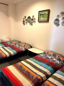 Dos camas una al lado de la otra en una habitación. en ゲストハウスブルーオーシャン那覇, en Naha