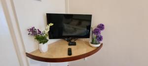 a tv sitting on a table with flowers in vases at Hotel Sai Palace in Satara