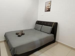 a bed in a white room with a stuffed animal on it at kkLee Homestay Taiping Tmn Spg Bersatu in Simpang