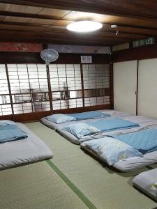 una camera con tre letti in una stanza con finestra di Minshuku Mariko / Vacation STAY 895 a Mochimune