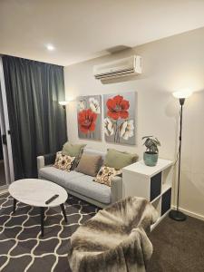 a living room with a couch and a table at The Metropolitan Apartments in Canberra