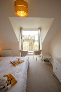 a bedroom with a bed and a large window at Martello Sunrise - Luxury 3-bedroom Seaview Beach House in Felixstowe