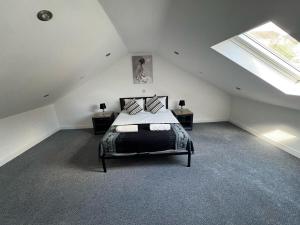 1 dormitorio en el ático con cama y ventana en City Escape – 1 Bedroom Flat in Swansea Centre, en Swansea