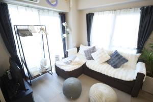 a living room with a bed with pillows on it at Mezon Etowaaru in Nagoya