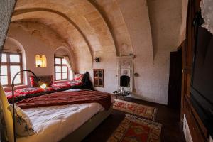 a bedroom with a bed in a room with an archway at Katre Cave House in Ürgüp