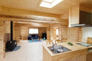 a log cabin kitchen and living room with a stove at Natural Retreat Mountain Blue / Vacation STAY 2336 in Hakusan