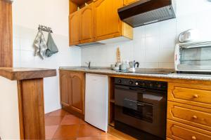 a kitchen with wooden cabinets and a stove top oven at Ski Slopes 1km - Aprica Baradello Apartment for 6 guests in Le Bratte