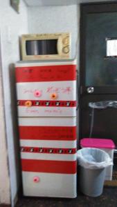 ein rot-weißer Kühlschrank mit einer Mikrowelle darauf in der Unterkunft furorai KANAMATI Floral Kanamachi - Vacation STAY 12219 in Tokio