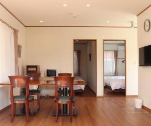 a living room with a table and chairs and a bedroom at The Hirosawa City Dome House West Building / Vacation STAY 18763 in Chikusei