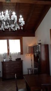 a dining room with a chandelier hanging from the ceiling at B&B Maison La Coccola in Peschiera del Garda