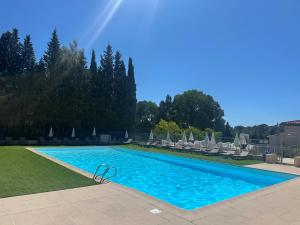 una piscina con tumbonas y una piscina en Hôtel Golf & Spa Château de la Bégude The Originals Collection, en Valbonne