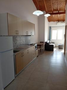 a kitchen with white appliances and a living room at Tourni Cozy Chios in Chios +4 photos