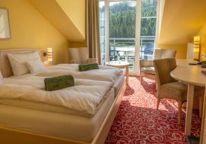 a hotel room with a bed and a table and chairs at Waldhaus am See in Willingen +20 photos