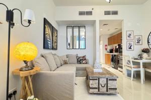 アブダビにあるReem Cozy Studio - Comfortable Stay Near Reem Mall & Waterfrontのソファとテーブルのあるリビングルーム