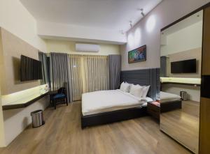 a hotel room with a bed and a mirror at White Orchid Sapphire in Cox's Bazar