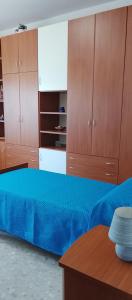a bedroom with a blue bed and wooden cabinets at Chloe's house in Agropoli
