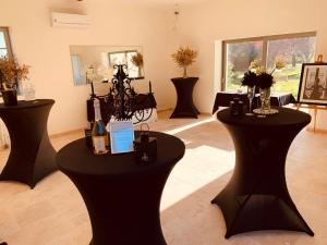 ein Raum mit schwarzen Tischen mit Blumen und Vasen in der Unterkunft Le Verger Des Pierres Blanches,11 chambres,11 wc, 8 sdbs,pool chauffée 11 m 35p in Mont-près-Chambord