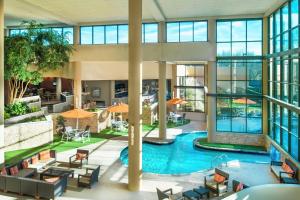 an indoor pool in a building with windows at Sheraton Charlotte Airport in Charlotte