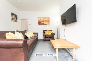 a living room with a couch and a table and a tv at Cosy 2BR House in Bolton with Free WiFi & Parking in Bolton