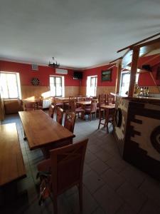 een restaurant met houten tafels en stoelen en een open haard bij Chalupa u Čarodějky in Vernířovice
