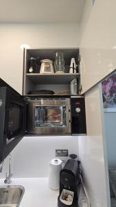 a small kitchen with a microwave and a sink at Intempo Apartment 13E by VivaMar in Benidorm