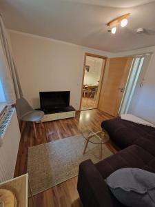 a living room with a couch and a flat screen tv at Ferienwohnung Dorfglück in Unterammergau