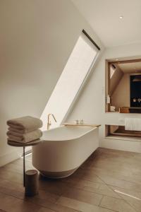 a bathroom with a bath tub and a window at Aethos London Shoreditch in London