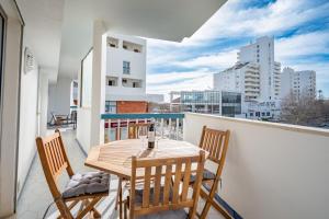 a balcony with a wooden table and two chairs at Charming Flat with Balcony - Portimão by HostWise in Portimão