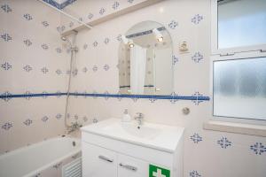 a bathroom with a sink and a mirror at Charming Flat with Balcony - Portimão by HostWise in Portimão +12 photos