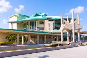 a building with a sculpture in front of it at Tsukasa Condo Chatan Alaha in Chatan