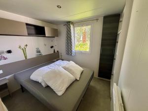 a small bedroom with a bed and a window at Mobil-home 4-6 personnes proche zoo de beauval in Veuzain-sur-Loire