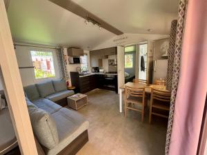 a living room and kitchen with a couch and a table at Mobil-home 4-6 personnes proche zoo de beauval in Veuzain-sur-Loire