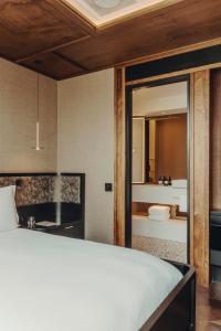 a bedroom with a white bed and a bathroom at Aethos London Shoreditch in London