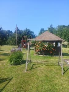 a garden with a gazebo and a playground at Agroturystyka Spokojna domek 5 osobowy in Pogorzelica +4 photos
