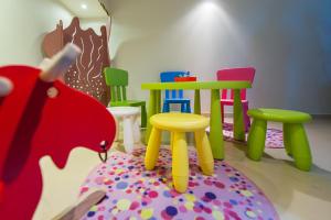 a room with colorful chairs and a table and stool at Hotel Alexander in Krakow