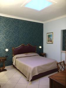 那不勒斯Hotel Serena的带床和绿墙的卧室