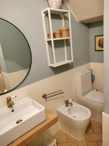 Un baño con lavabo, inodoro y espejo. en Casa Tosca, en Montevarchi 1 foto más