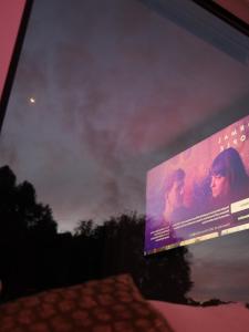 a movie poster on the side of a television screen at Kangaroo Island Seaside Nature Retreat - Melalueca in Pelican Lagoon +39 photos