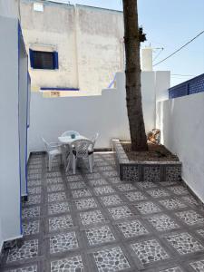a patio with a table and a tree at Chez hamid in Oualidia
