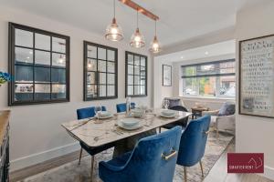 Un comedor con una mesa y sillas azules. en Holyport - Three Bedroom House - Parking, en Maidenhead