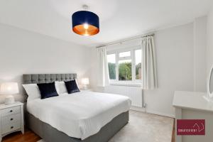 Un dormitorio con una cama grande y una ventana en Holyport - Three Bedroom House - Parking, en Maidenhead