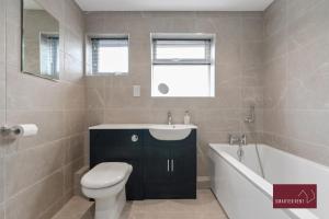 Un baño con inodoro, lavabo y bañera. en Holyport - Three Bedroom House - Parking, en Maidenhead 18 fotos más